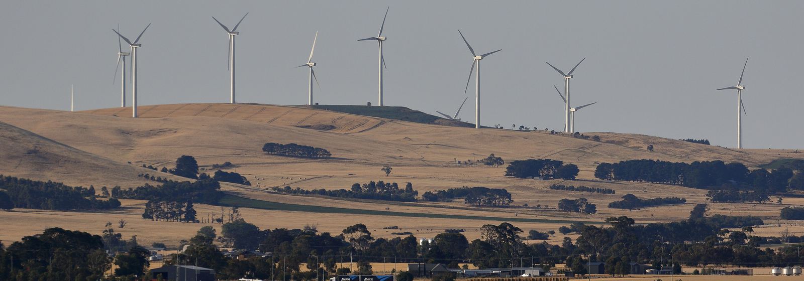 Wind turbines along a ridgeline above dry farmland at Waubra, Victoria